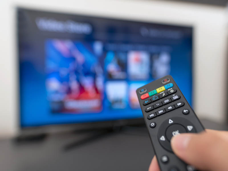 Multimedia streaming concept. Hand holding remote control