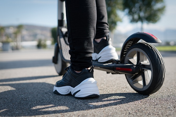 Woman on an electric scooter on the road.