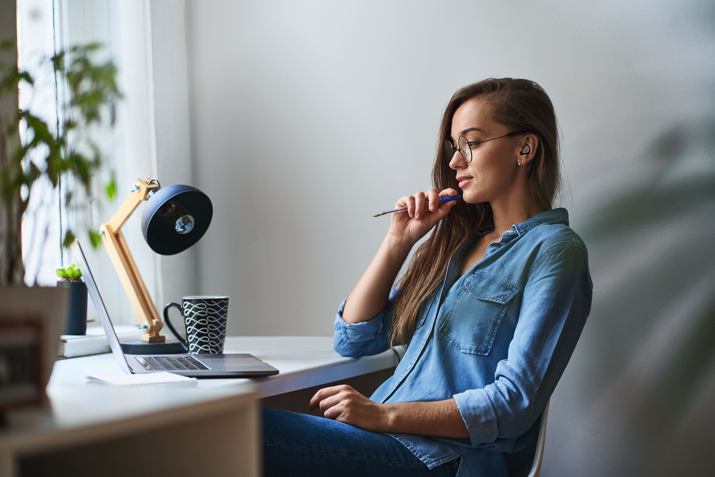 Casual young concentrated woman wearing round glasses working on