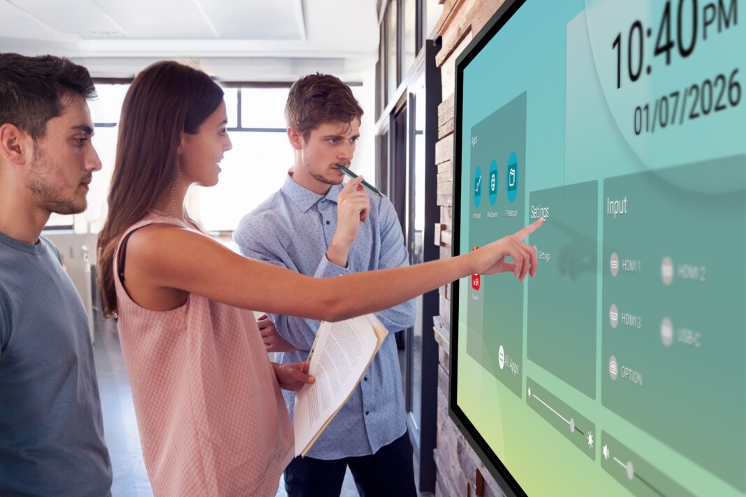 Young,Man,And,Woman,In,Discussion,At,Whiteboard,In,An